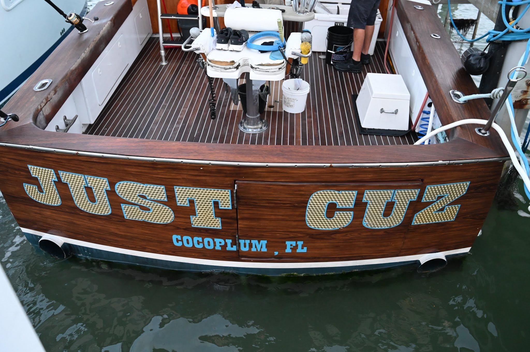 Just Cuz gold and blue lettering on the varnished teak stern